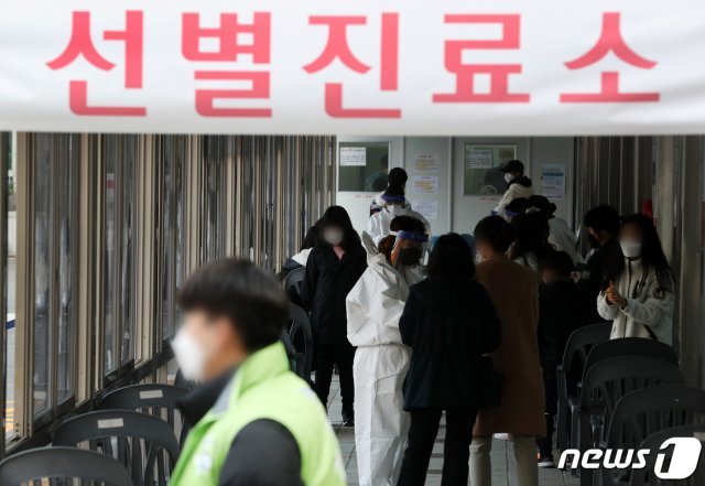 13일 오후 서울 동대문구보건소에 마련된 신종 코로나바이러스 감염증(코로나19) 선별 진료소에서 시민들이 줄을 서고 있다. /뉴스1 © News1