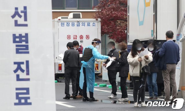 국내 신종 코로나바이러스 감염증(코로나19) 신규 확진자 수가 300명대로 급증한 18일 서울 중구 국립중앙의료원 선별진료소에서 시민들이 검사 영수증을 받고 있다. 신규 확진자 수가 300명대를 기록한 건 지난 8월21일(324명) 이후 처음이다. 2020.11.18/뉴스1