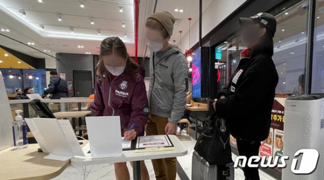 18일 오후 서울 용산구의 한 쇼핑몰 내 패스트푸드점에 시민들이 출입자 수기명부를 작성하고 있다. 2020.11.18/뉴스1 © News1