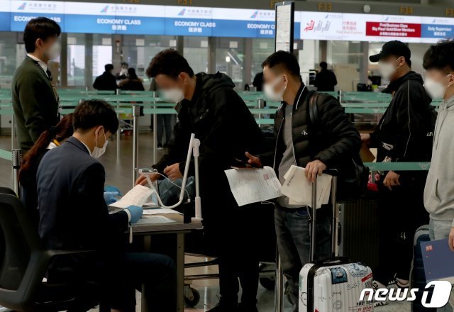 12일 오후 인천국제공항 1터미널 출국장 중국 항공기 체크인카운터에서 승객들이 신종 코로나바이러스 감염증(코로나19)에 걸리지 않았다는 것을 증명하는 음성확인서를 두 장을 공항 관계자에게 보여주고 있다.2020.11.12/뉴스1 © News1