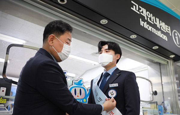 백진욱 사업본부장(왼쪽)이 검암역 이성 역무원(오른쪽)에게 ‘마스크가 최고의 백신’ 배지를 달아주고 있다.