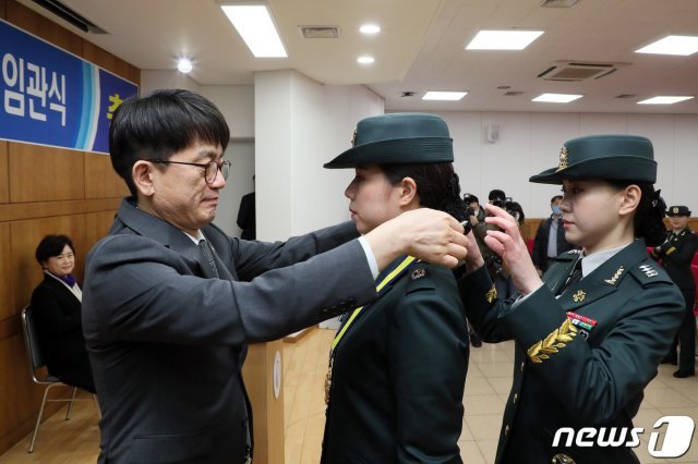 박재민 국방부 차관이 지난 3월 서울 성북구 성신여자대학교에서 열린 ‘2020년 성신여대 학군단 장교 임관식’에서 대통령상을 수상한 이수지 육군 소위에게 상장을 수여한 후 메달을 걸어주고 있다. (국방부 제공) 2020.3.2/뉴스1