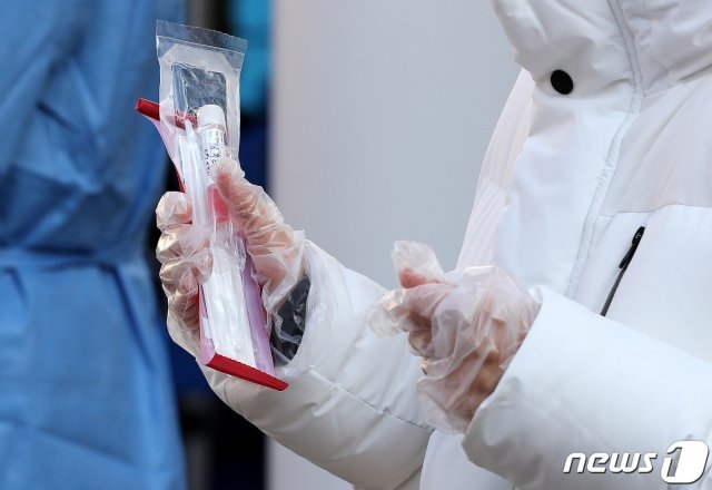 서울 동작구청 주차장에 마련된 현장 선별진료소를 찾은 시민이 신종 코로나 바이러스 감염증(코로나19) 검사 진단 키트를 들고 있다. 2020.11.25 © News1