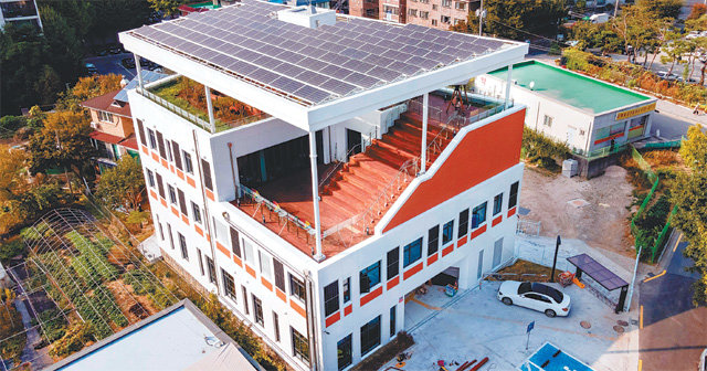 서울 강동구 둔촌도서관. 건물 밖으로 빠져나가는 에너지를 줄이고 내부에서 사용하는 에너지 효율은 끌어올렸다. 태양광 패널은 신재생에너지를 생산할 뿐 아니라 옥상 정원의 그늘막 역할도 한다. 강동구 제공