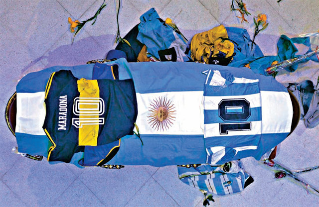 국기-10번 유니폼으로 감싸고… 심장마비로 세상을 떠난 축구 영웅 디에고 마라도나의 관이 26일 아르헨티나 
부에노스아이레스의 대통령궁 카사로사다에 안치됐다. 아르헨티나 국기가 그의 관을 감싼 가운데 그의 선수 시절 등번호 10번이 새겨진
 국가대표 유니폼과 그가 몸담았던 보카 주니어스 유니폼이 관 위에 놓였다. 수많은 추모객들이 몰려들어 꽃과 유니폼 등을 던지며 
애도를 표시했다. 부에노스아이레스=AP 뉴시스