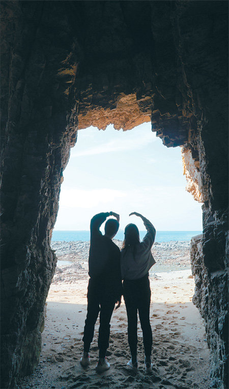 연인들의 기념사진 명소로 최근 입소문을 타고 있는 파도리 해식동굴은 동굴 너머로 보이는 해변과 바다의 풍경이 사람의 실루엣과 잘 어울린다.