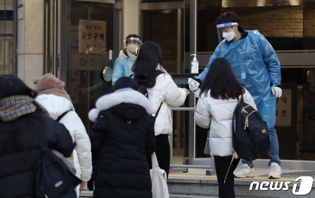 2021학년도 대학수학능력시험일인 3일 오전 서울 서초구 반포고등학교에서 수험생들이 입장 전 손소독을 하고 있다. 신종 코로나바이러스 감염증(코로나19) 여파로 2주 늦춰진 이번 수능은 역대 최소인 49만3433명이 응시한 가운데 전국 86개 시험지구 1383개 시험장에서 일제히 치러진다. 2020.12.3/뉴스1 © News1 사진공동취재단