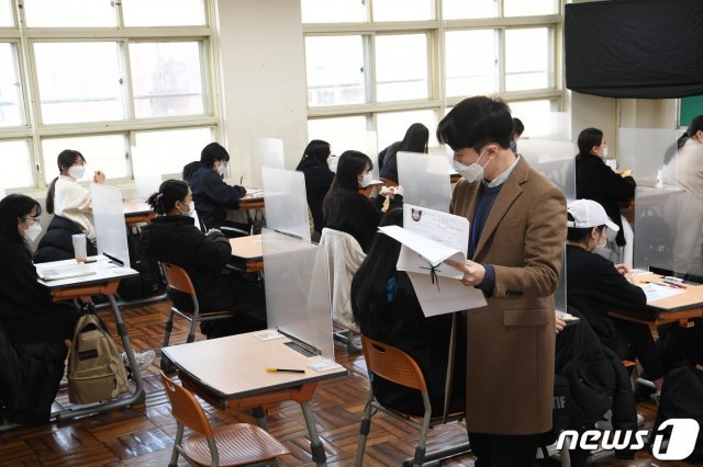 2021학년도 대학수학능력시험이 실시된 3일 오전 수험장이 마련된 부산 동구 경남여자고등학교에서 감독관들이 수험생의 신원을 확인하고 있다. 2020.12.3/뉴스1 © News1