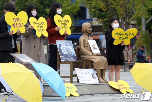 전북 대학생겨례하나 소속 대학생들이 14일 전북 전주시 풍남문 광장 평화의소녀상 옆에서 ‘베를린 평화의소녀상 철거 반대’ 수요집회를 열고 할머니 생애 낭독을 하고 있다. 2020.10.14/뉴스1 © News1