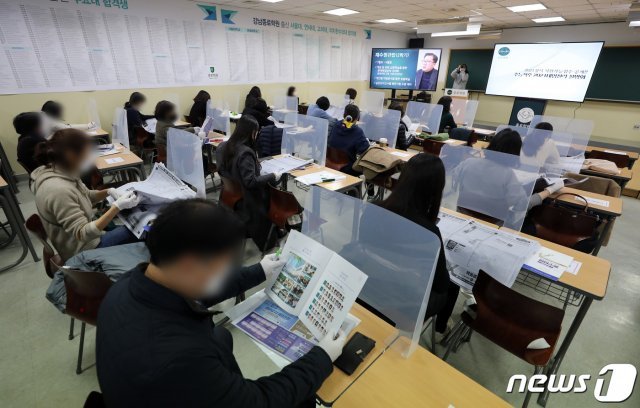 4일 오후 서울 강남구 종로학원에서 열린 2021학년도 대학수학능력시험 합격예측점수 설명회를 찾은 학무보들이 배치참고표를 살펴보고 있다. 이날 설명회는 신종 코로나바이러스 감염증(코로나19) 사회적 거리두기 방역지침에 따라 최소한의 제한된 인원만 참석한 채 온라인으로 생중계 했다. 2020.12.4 © News1