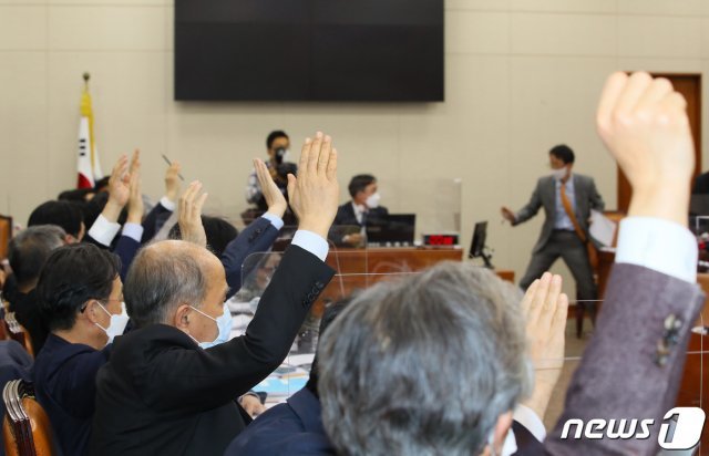 7일 오후 서울 여의도 국회에서 열린 정무위원회 전체회의에서 의원들이 의사일정 상정에 대한 변경동의에 관해 손을 들어 표결을 하고 있다.  2020.12.7/뉴스1 © News1