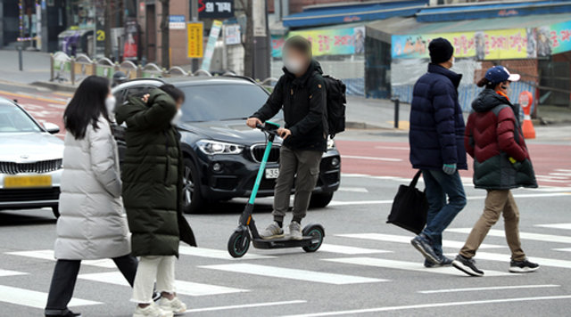 10일 서울 시내에서 한 시민이 전동킥보드에 탄 채 횡단보도를 건너고 있다. 뉴시스