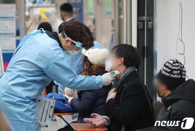 10일 오전 서울 중구 보건소에 마련된 신종 코로나바이러스 감염증(코로나19) 선별진료소를 찾은 시민들이 검사접수 및 역학조사에 앞서 발열체크를 받고 있다. 2020.12.10/뉴스1 © News1