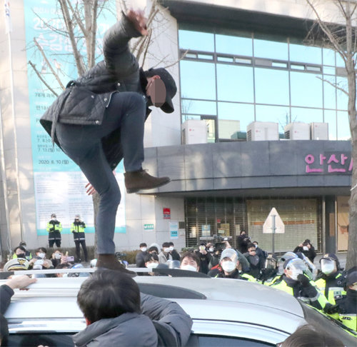 12일 오전 경기 안산준법지원센터에서 나와 자택으로 향하는 조두순을 태운 차량 위에 올라간 한 시민이 발길질을 하고 있다. 안산=뉴시스