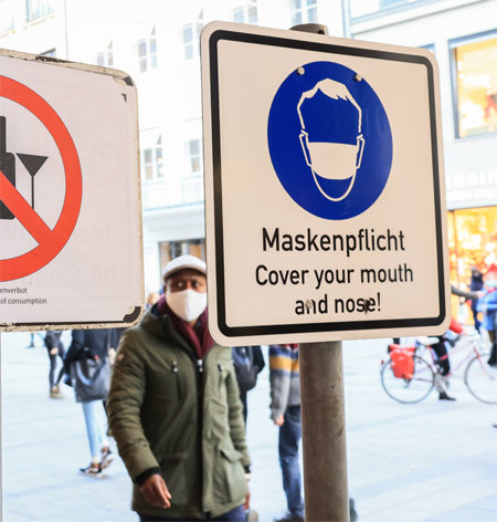 11일(현지 시간) 독일 남부 뮌헨에서 행인들이 ‘마스크 착용 의무화’를 뜻하는 표지판 옆을 지나가고 있다. 독일 정부는 16일부터 약국, 식료품 매장 등을 제외한 모든 상점을 폐쇄하는 방안을 추진하고 있다. 뮌헨=AP 뉴시스