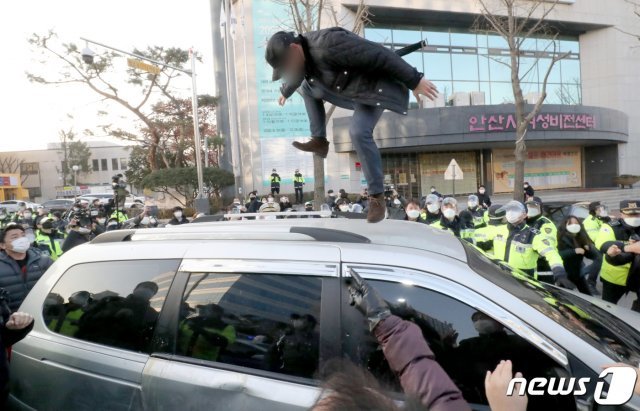 지난 12일 오전 안산시내에서 한 유튜버가 거주지로 향하는 조두순이 탑승한 차량을 공격하고 있다. 2020.12.12/뉴스1 © News1