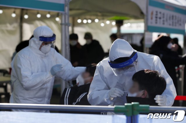 서울 중구 서울역광장에 마련된 코로나19 임시 선별진료소에서 의료진이 검체 채취를 하고 있다. 2020.12.16/뉴스1 © News1