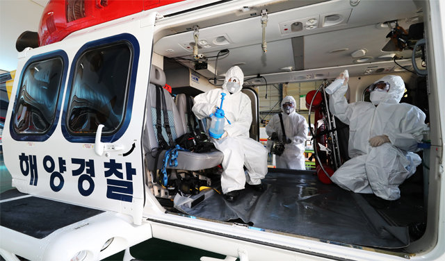 16일 인천 중부지방해양경찰청 소속 경찰관들이 신종 코로나바이러스 감염증을 예방하기 위해 응급 환자 이송에 투입되는 구조헬기를 소독하고 있다. 인천=뉴스1