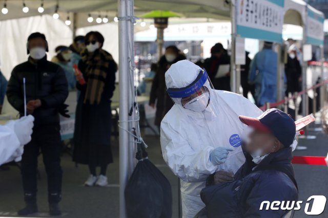 16일 오전 서울 중구 서울역광장에 마련된 코로나19 임시 선별진료소에서 의료진이 검체 채취를 하고 있다. 2020.12.16/뉴스1 © News1