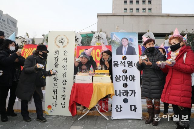 윤석열 검찰총장의 생일인 18일 오전 대검찰청앞에서 윤총장 없는 ‘환갑잔치’가 열렸다.윤석열 총장을 지지하는 수 십명의 시민들이 
머리에 고깔을 쓴 채 시민들에게 떡을 돌렸고 미리 준비한 축하케익에 촛불을 꼿고 불을 붙이기도 했다.