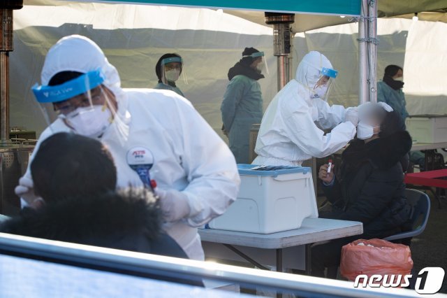 임시 선별진료소에서 관계자가 시민들의 검체 채취를 하고 있다./뉴스1 © News1