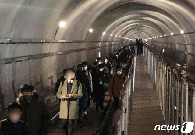 21일 오후 6시 30분께 김포 골드라인 경전철이 김포공항역에서 고촌역사이에서 멈춰서 시민들이 큰 불편을 겪고 있다. 이 차량에 50여분간 갇혀 있던 약 300여명의 승객들이 열차 선로 위 비상통로로 고촌역까지 걸어가고 있다. 2020.12.21/뉴스1 © News1