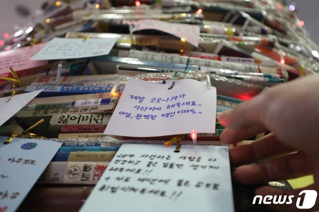 크리스마스를 앞두고 8일 오후 대구대학교 경산캠퍼스 중앙도서관 1층 로비에서 학생들이 ‘소망 북(Book) 트리’에 새해 소원을 적은 종이를 붙이고 있다. 2020.12.8/뉴스1 © News1