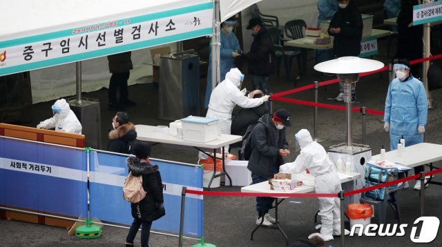 23일 오전 서울역 광장에 마련된 임시 선별진료소에서 관계자가 시민들의 검체 채취를 하고 있다. 2020.12.23/뉴스1 © News1