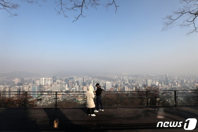 지난 24일 오전 서울 남산을 찾은 시민이 미세먼지로 뒤덮인 도심을 바라보고 있다.  2020.12.24/뉴스1 © News1