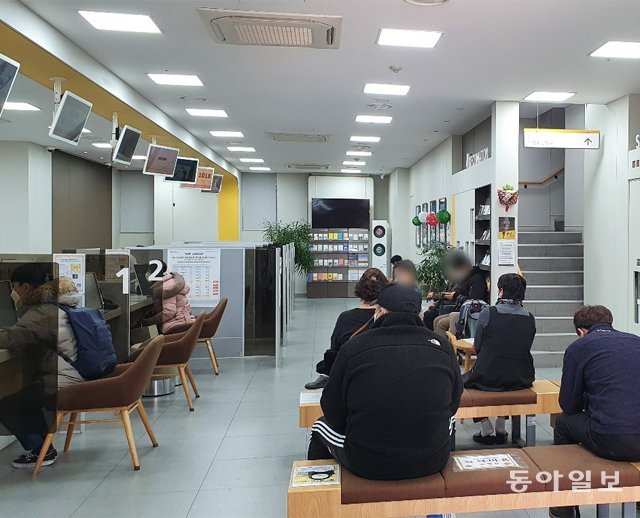 28일 서울 종로구의 한 은행 지점에서 20명 넘는 고객이 차례를 기다리고 있다. 이날부터 코로나19 확산 방지를 위해 
영업점에 머무는 고객을 가급적 10명 이내로 제한하기로 했지만 이를 지키지 않는 지점들이 많았고, 일부 지점은 안내문조차 없었다.
 신나리 기자 journari@donga.com