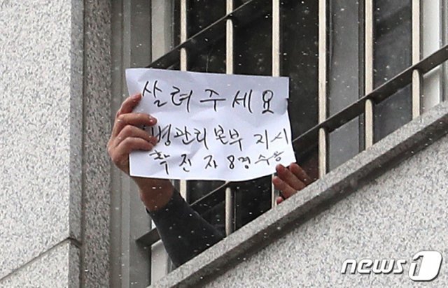 대규모 집단감염이 발생한 서울 동부구치소에 수용된 재소자가 지난  29일 자필로 ‘살려주세요’라고 쓴 문구를 내보이고 있다.