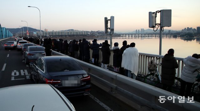 1일 오전 서울 한강의 동작대교 위에서 수많은 시민들이 2021년 첫 일출을 기다리고 있다. 최혁중 기자 sajinman@donga.com