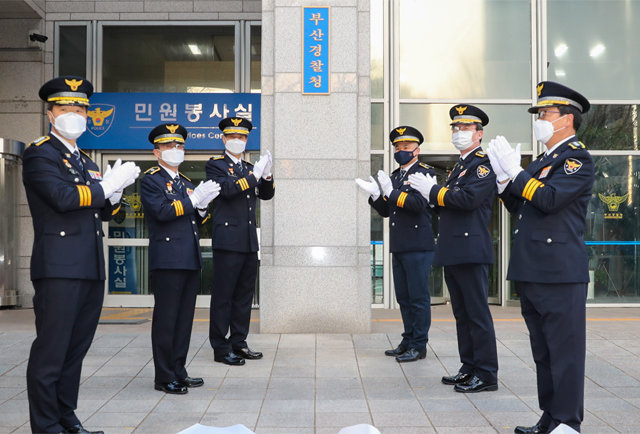 부산지방경찰청의 공식 명칭이 30년 만에 부산광역시경찰청으로 바뀌었다. 진정무 부산경찰청장(왼쪽에서 세 번째)과 간부들이 4일 오전 현판을 교체한 뒤 박수를 치고 있다. 부산경찰청 제공