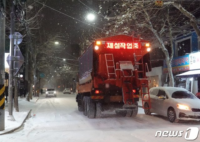 6일 오후 곳곳에 한파와 대설 특보가 발효된 가운데 서울 마포구 홍대입구역 인근에 눈이 소복히 쌓여있다. 제설차량이 이면도로 눈을 치우며 염화칼슘을 뿌리고 있다. 2020.1.6/뉴스1 © News1