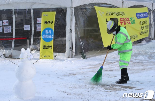 7일 오전 서울 서울 용산역 앞 코로나19 임시선별검사소 앞에서 환경미화원이 제설작업을 하고 있다. 2021.1.7/뉴스1 © News1