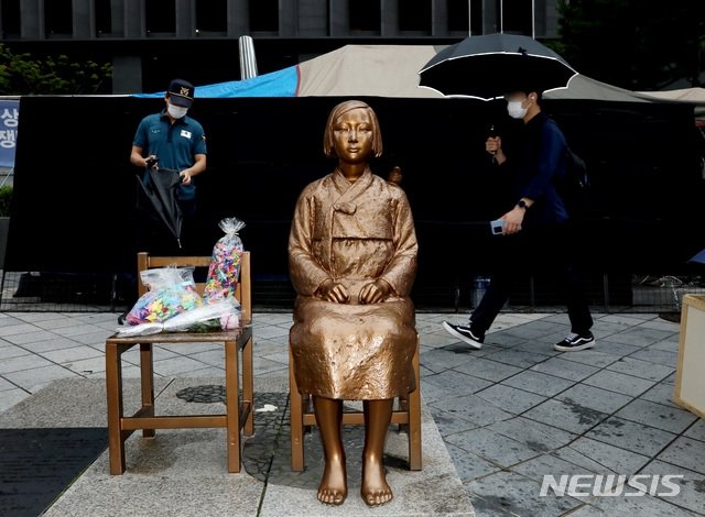 서울 종로구 옛 일본대사관 앞 평화의 소녀상 뒤로 시민들이 이동하고 있다. 뉴시스