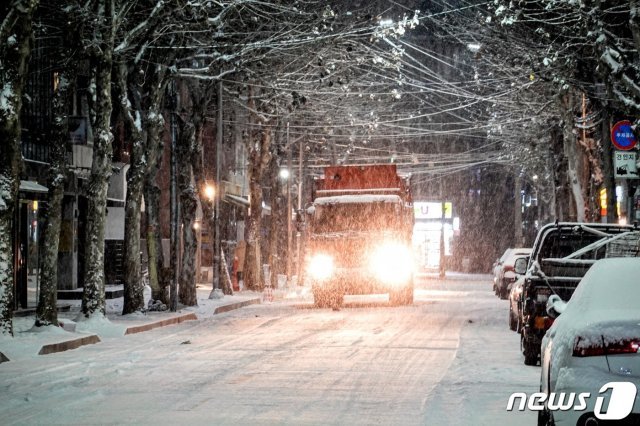 6일 오후 곳곳에 한파와 대설 특보가 발효된 가운데 서울 마포구 홍대입구역 인근에 눈이 쌓이고 있다. 제설차량이 이면도로에 염화칼슘을 뿌리고 있다. 2020.1.6/뉴스1 © News1