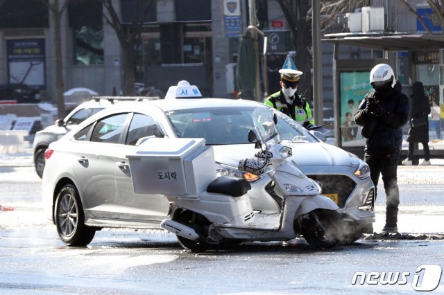 서울 광화문 사거리에서 지난 7일 교통사고가 발생해 배달 노동자가 사고를 처리하고 있다.2021.1.7/뉴스1 © News1