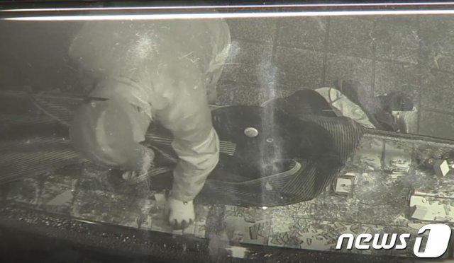 광주 남부경찰서는 특수절도 혐의로 광주 서부경찰서 한 파출소 소속 A경위를 붙잡아 조사 중이라고 지난 7일 밝혔다. A경위는 지난해 12월18일 오전 4시쯤 광주 남구의 한 금은방에 침입해 금목걸이와 반지 등 2500만~3000만원 상당의 귀금속을 훔쳐 달아난 혐의를 받고 있다. 사진은 A경위가 도구를 이용해 귀금속을 훔치는 모습.(독자제공 CCTV 영상 캡처) 2020.1.7/뉴스1 © News1