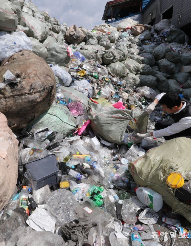 지난해 4월 경기 포천시의 한 재활용품 수거업체 직원이 수거한 폐플라스틱 더미를 살펴보고 있다. 환경부는 2030년까지 수입량이 많은 10대 폐기물의 수입을 금지하기로 했다. 동아일보DB