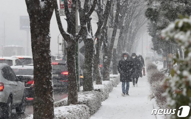 12일 오후 서울 서초구 양재꽃시장 인근에서 시민들이 갑자스러운 폭설에 발걸음을 재촉하고 있다. 오후부터 서해안 쪽에서 시작된 눈이 수도권과 서울로 번지고 있다. 2021.1.12/뉴스1 © News1