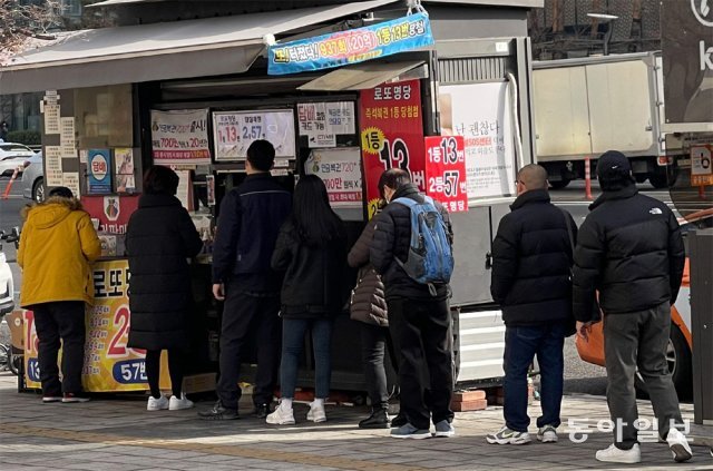 14일 서울 잠실역 인근 로또 판매점 앞에 로또를 사려는 대기 줄이 길게 늘어서 있다. 원대연 기자 yeon72@donga.com