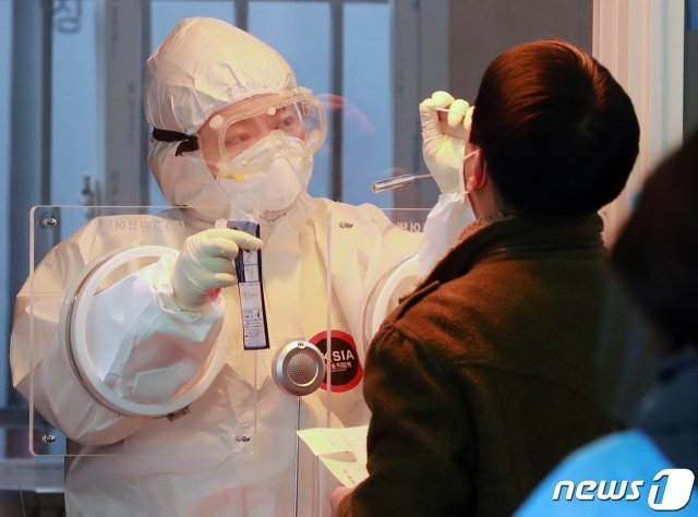 14일 오전 서울역 광장에 마련된 신종 코로나바이러스 감염증(코로나19) 임시선별진료소에서 의료진이 피검사자의 검체를 채취하고 있다. © News1