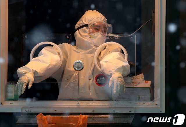 18일 오후 서울역 앞 광장에 마련된 코로나19 임시선별진료소에서 의료진이 함박눈을 바라보며 생각에 잠겨 있다. /뉴스1 © News1