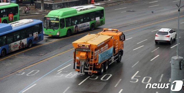 18일 서울 중구 서울역 앞 한강대로에서 서울시 제설차량이 염화칼슘을 뿌리고 있다. 기상청은 이날 오후까지 중부지방에 최대 15㎝의 많은 눈이 올 것으로 전망했다. 2021.1.18/뉴스1 © News1