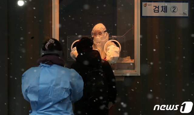 18일 오후 서울역 앞 광장에 마련된 코로나19 임시선별진료소에서 의료진이 검체를 채취하고 있다. /뉴스1 © News1