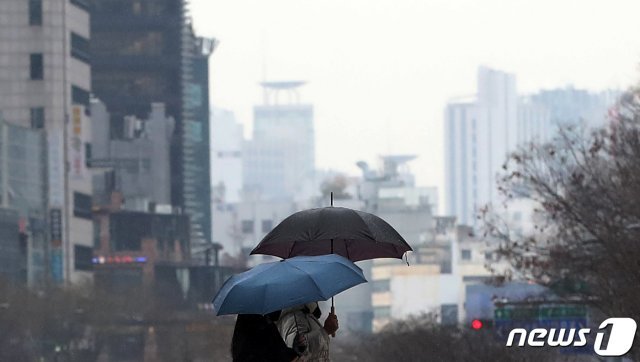 겨울비가 내린 21일 오후 서울 청계천에서 시민들이 우산을 쓴 채 산책하고 있다. 기상청은 당분간 큰 추위 없이 포근한 날들이 이어질 것으로 예보했다. 2021.1.21/뉴스1 © News1