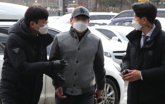 경기 김포의 한 아파트에서 자신의 지인 차량을 통과시켜 주지 않았다는 이유로 경비원들을 폭행해 중상을 입힌 30대 중국인 입주민이 18일 오후 경찰 조사를 받기 위해 김포경찰서에 들어서고 있다. 뉴스1
