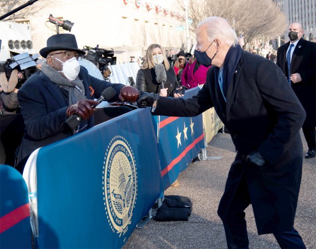 취재진과도 인사 조 바이든 미국 대통령(오른쪽)이 20일(현지 시간) 자신의 취임식을 취재하기 위해 워싱턴 백악관 앞 펜실베이니아 애비뉴를 찾은 취재진과  주먹인사를 나누고 있다. 워싱턴=AP 뉴시스