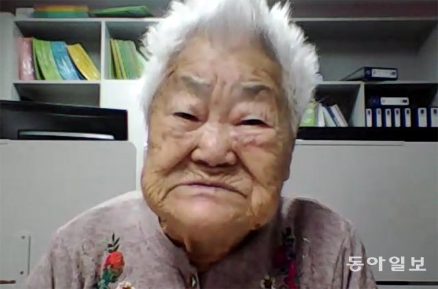 경기 광주시 ‘나눔의집’에서 생활하고 있는 일본군 위안부 피해자 이옥선 할머니가 나눔의집 관계자들의 도움을 받아 24일 본보와 온라인 화상 인터뷰를 하고 있다. 박상준 기자 speakup@donga.com